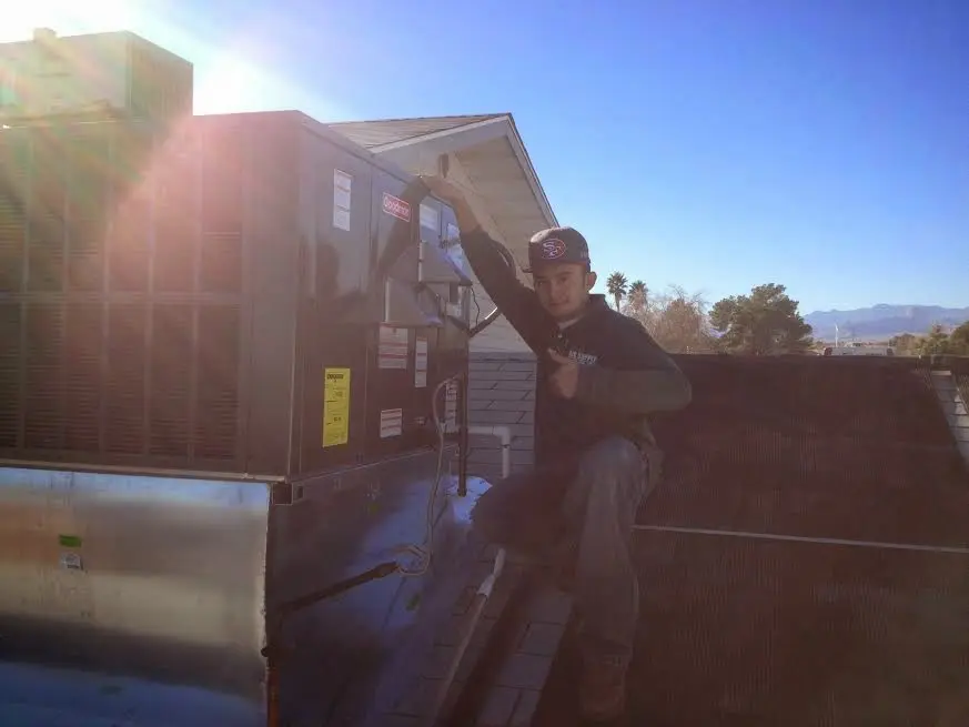 HVAC technician performing AC Tune-Up on a rooftop unit in Phenix City